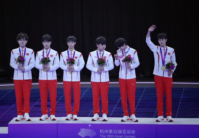 杭州亚运会，中国队夺得王者荣耀项目冠军，孙麟威（左一）和俱乐部队友罗思源（左二）登上领奖台。  新京报记者 薛珺 摄