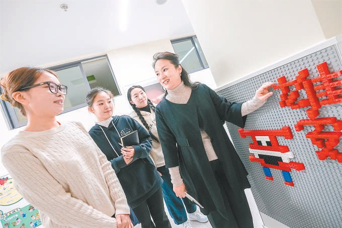 殷珺（右）正在与年轻教师交流。 本报记者 武亦彬摄