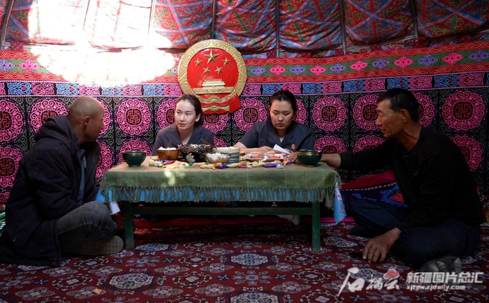 法官阿热艾·巴合特别克（左二）为村民调解纠纷。本人供图