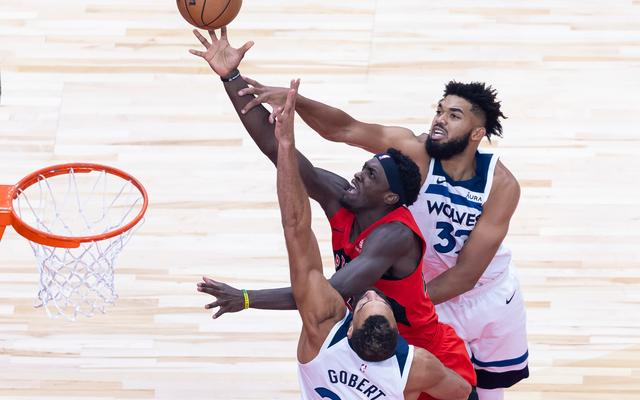 戈贝尔（下）和唐斯（上）包夹防守猛龙球员西亚卡姆。  图/新华社