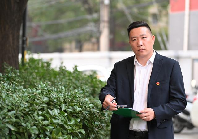 10月24日，胡浩在小区里日常巡视，并随时记录发现的问题。新京报记者 陶冉 摄