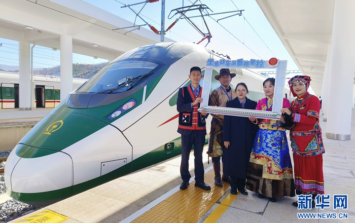 香格里拉站站台上，各族群众、列车工作人员在复兴号动车前留影（摄于11月26日）。新华网发（黄再云 摄）