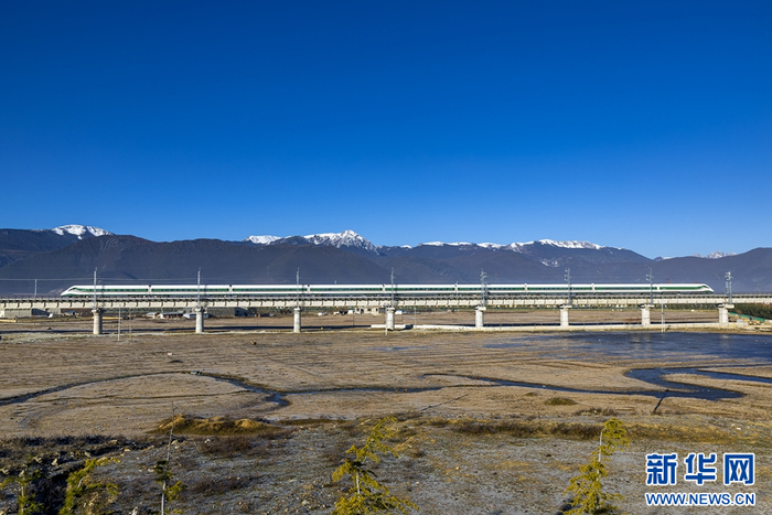 丽香铁路线上，列车与雪山“同框”（摄于11月26日）。新华网发（陈畅 摄）