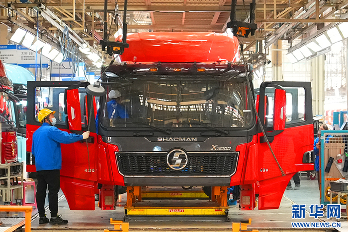 11月14日，在陕汽集团汽车总装配厂车间，两名工人忙着给卡车装配零部件。新华网 杨喜龙 摄
