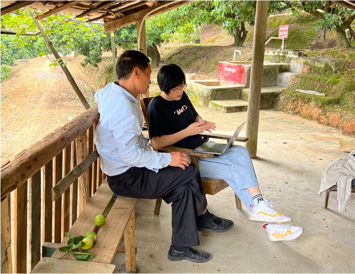 阿里巴巴农业数字化技术员在种植园与荔农进行交流
