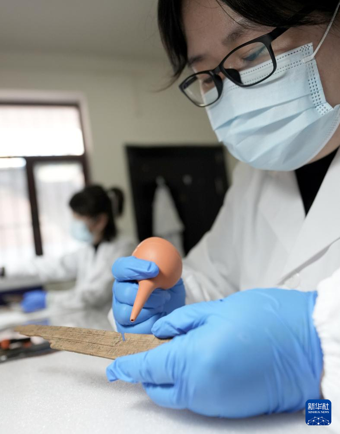 甘肃文博服务中心文物修复师李媛在清理简牍上灰尘（10月26日摄）。新华社记者 王毓国 摄
