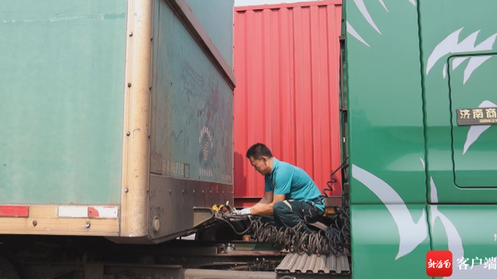 　　正在卸下货厢。记者 林鸿羽 摄