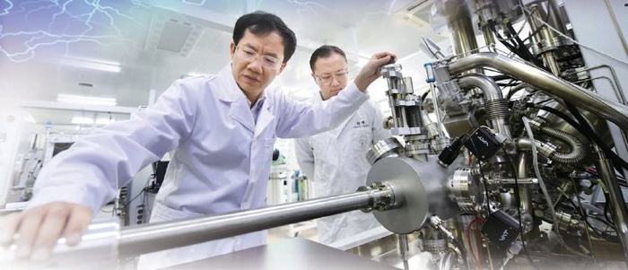 　　胡勇胜（左）与学生在实验室里本报记者 和冠欣摄