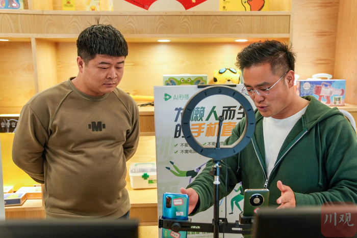 王芯福（右）向客户介绍AI数字人直播。