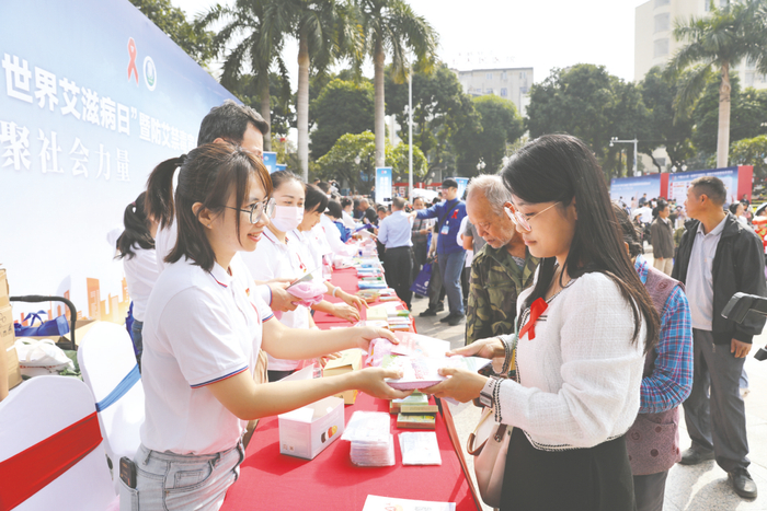 工作人员在广西2023年“世界艾滋病日”暨防艾禁毒宣传月活动启动仪式现场向群众发放宣传资料。（卢攀 摄）