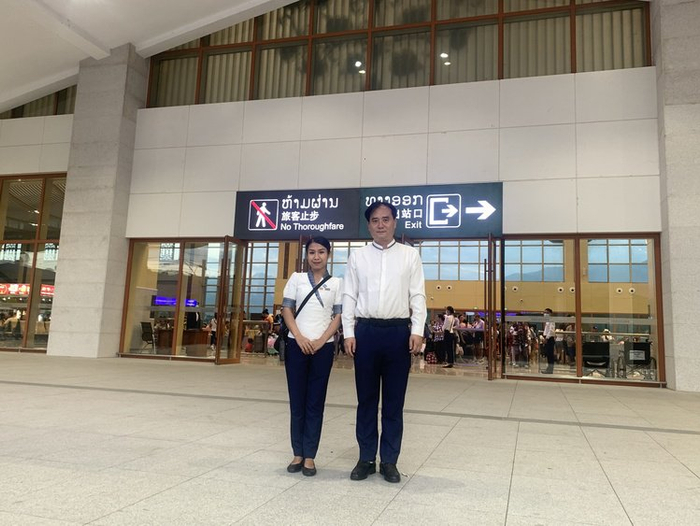 中老铁路琅勃拉邦中心站站长肖建国（图右）与老挝籍客运值班员芭塔娜