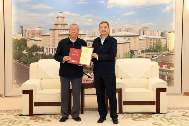哈尔滨工业大学负责同志向沈世钊院士（左）颁发教育贡献奖奖牌和捐赠证书。（来源：新华每日电讯）