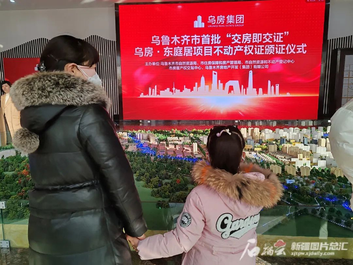 12月2日，乌鲁木齐市水磨沟区河马泉片区东庭居小区业主刘慧娟带女儿前来参加颁证仪式。记者魏红萍摄