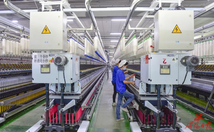 咸阳纺织集团有限公司生产车间内机器轰鸣，工人正在忙碌生产。咸阳日报全媒体实习记者 韩国章 摄 （资料图）