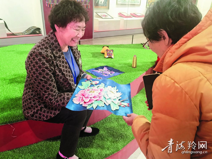 参观者与绣娘交谈。本报记者 张晓英 摄