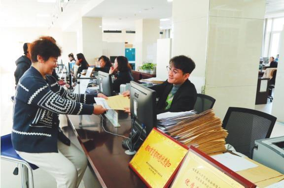         喀左县政务服务中心工作人员正在为群众办理业务。