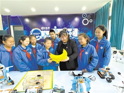 第十二师五一农场中学校长高洁参加学生科技社团活动。本报记者 蒋夫尔 摄