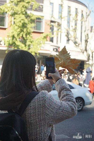 一位背包的游客正在武康大楼对面拍摄