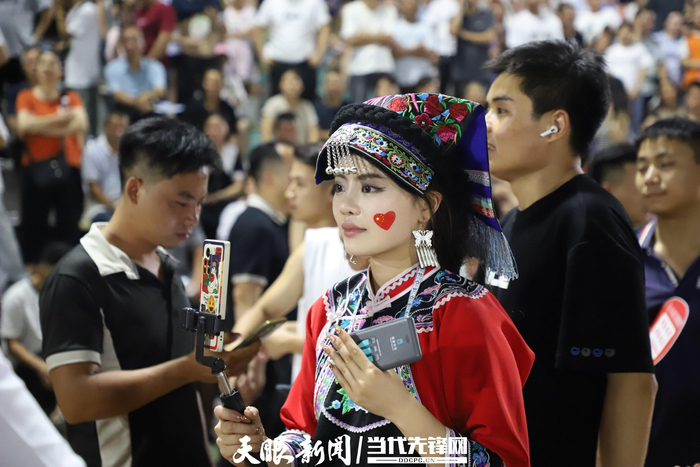 2023年6月17日，在“村超”联赛现场，一名少数民族网络主播直播热闹场面。谭必杰 摄