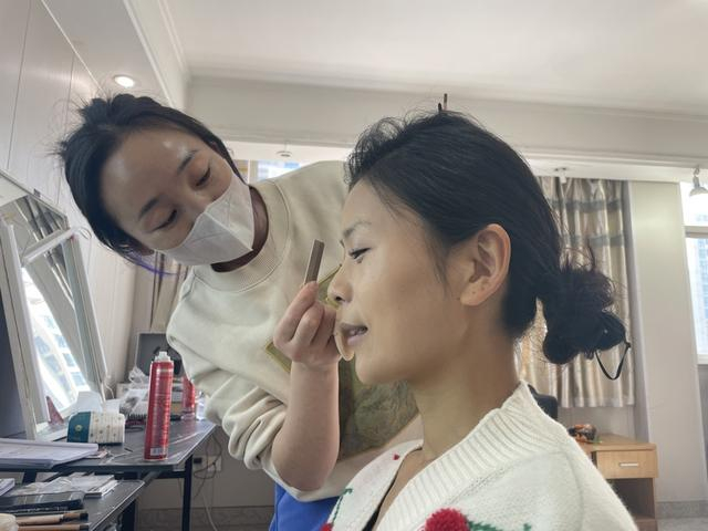 薛玉琼正在化妆。 于量 摄