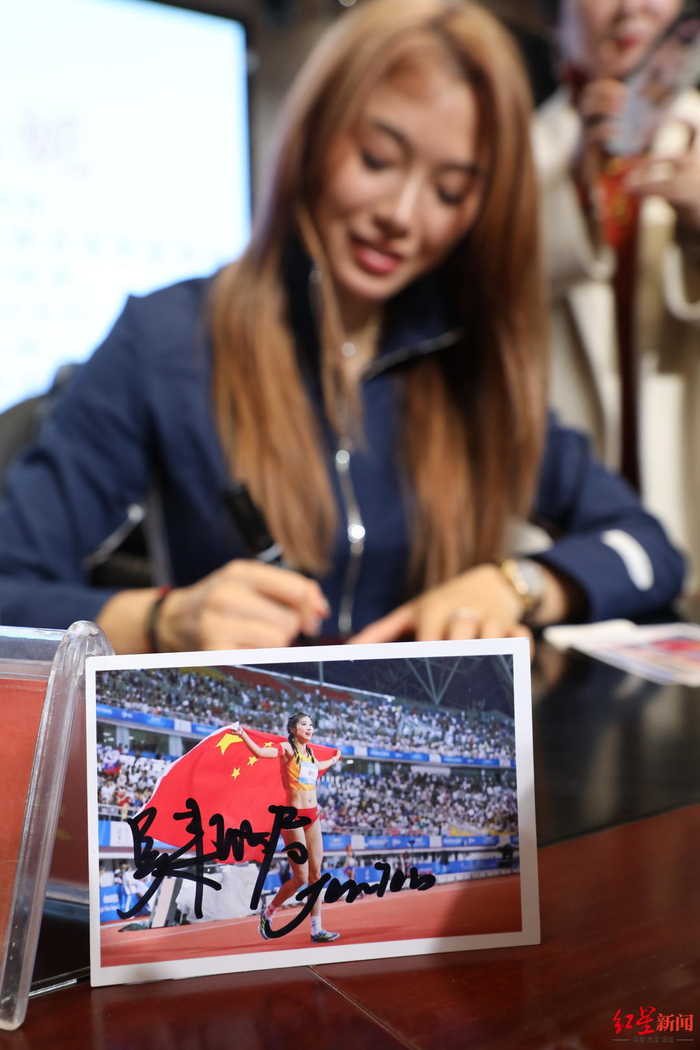 ▲吴艳妮给学生们签名留念