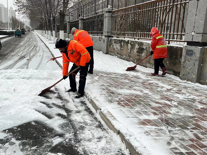 12月11日清晨，邯郸公交公司工作人员清理站牌前积雪，方便市民上下车。董源 摄