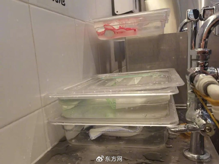 △门店装有红、绿、蓝三色消毒抹布的消毒水浸泡盒（图片来源：记者）