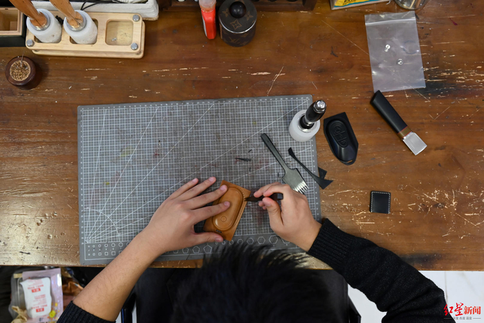 ▲王超正在制作汽车钥匙套