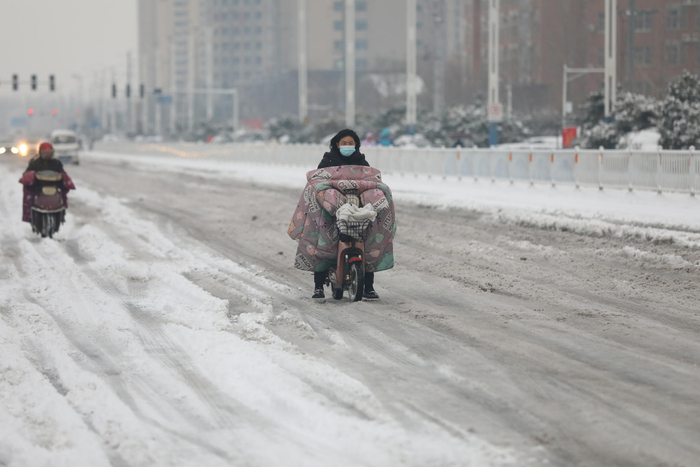 ▲12月11日，河南安阳，市民在积雪的道路上前行。图据ICphoto