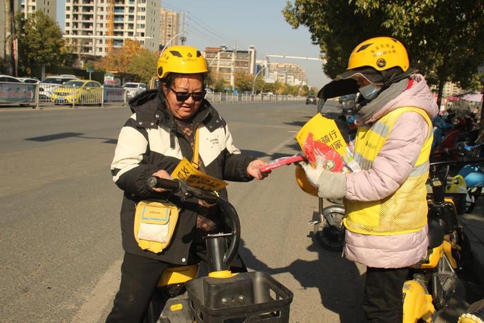 （图为松果出行志愿者在湖北省随州市向市民介绍交通安全知识）