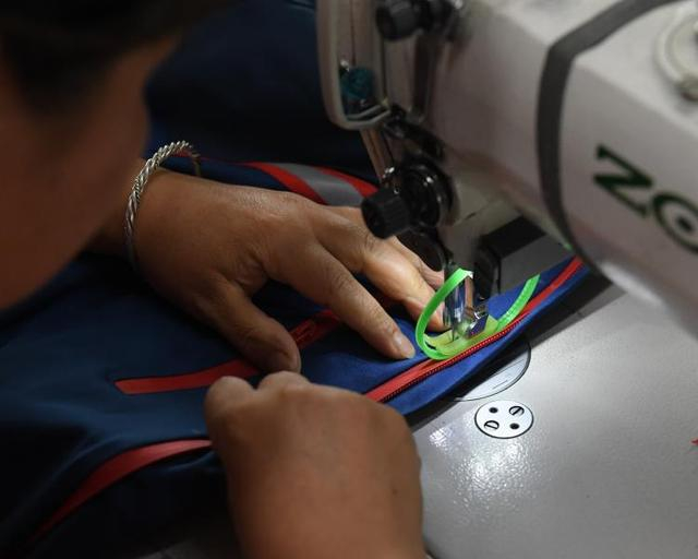 台州三门县一家户外用品公司工作人员在缝合冲锋衣拉链。 新华社记者 翁忻旸 摄