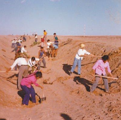 上世纪80年代，磴口县干部群众在挖掘灌溉渠。中国林科院沙漠林业实验中心供图