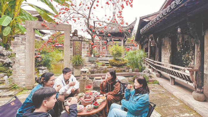 在西溪南古村落蔓园见山·归隐民宿，游客们正围坐畅聊。 本报记者 潘 成 摄