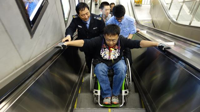 杜鹏在地铁工作人员的帮助下坐电梯。受访者供图