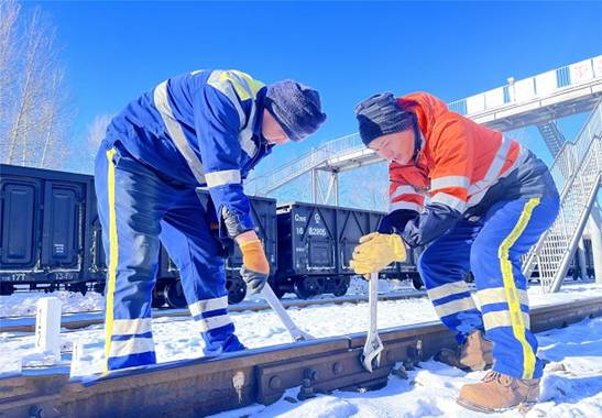 图为铁路职工正在极寒下紧固铁路道岔螺栓