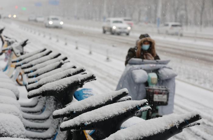 ▲12月14日,山东滨州,市民在街头冒雪骑行。图据视觉中国