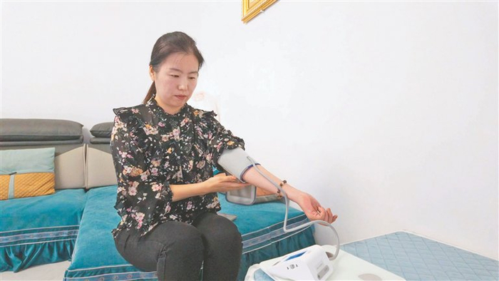     蒋女士在使用智能血压仪。