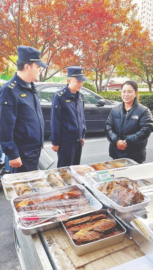     11月18日，定州市城管执法队员在便民规范经营区走访摊主。 河北日报通讯员 白永民摄