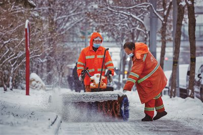 12月14日，大兴区天宫院，人行道上环卫工人正用小型除雪机除雪。新京报记者 尹亚飞 摄