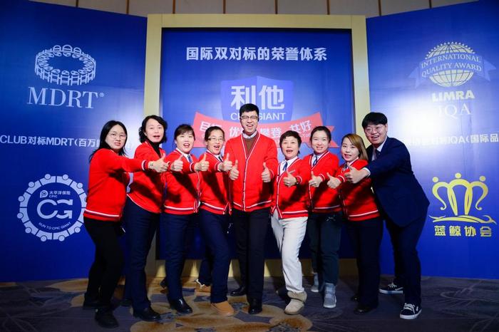 图说:中国太保寿险营销精英在利他绩优文化展板前合影