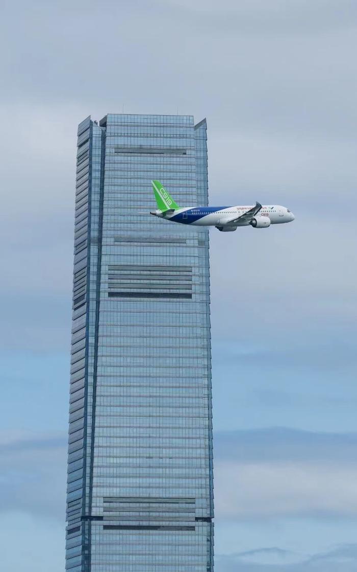 以上圖為國產大飛機c919飛越維港上空,掠過香港最高樓環球貿易廣場icc