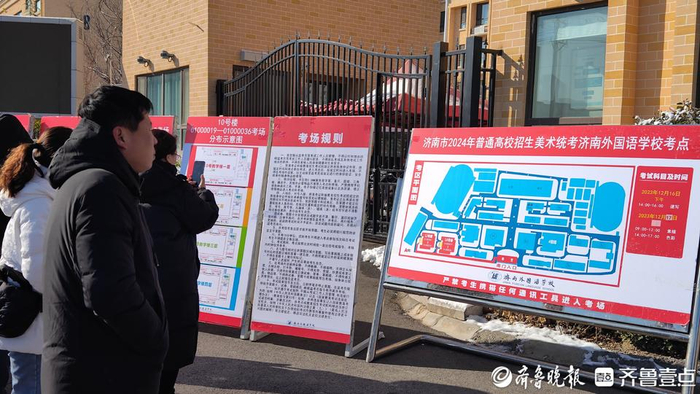 开考前，济南外国语学校考点外，陪考家长在看考场规则 摄影 王凯