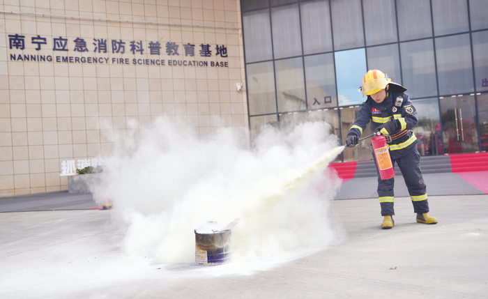     消防员示范正确使用干粉灭火器 本报记者覃祖稳摄