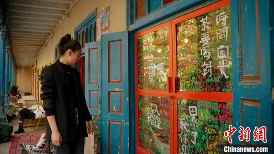 张媛媛和咖啡店玻璃上的涂鸦。赵凯 摄