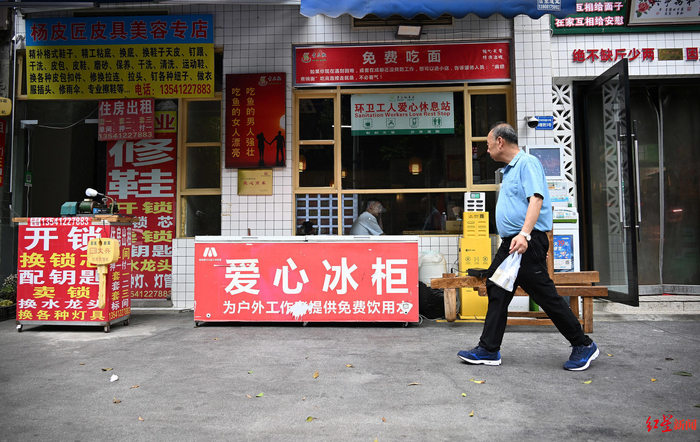 ▲市民走过餐馆外的爱心冰柜
