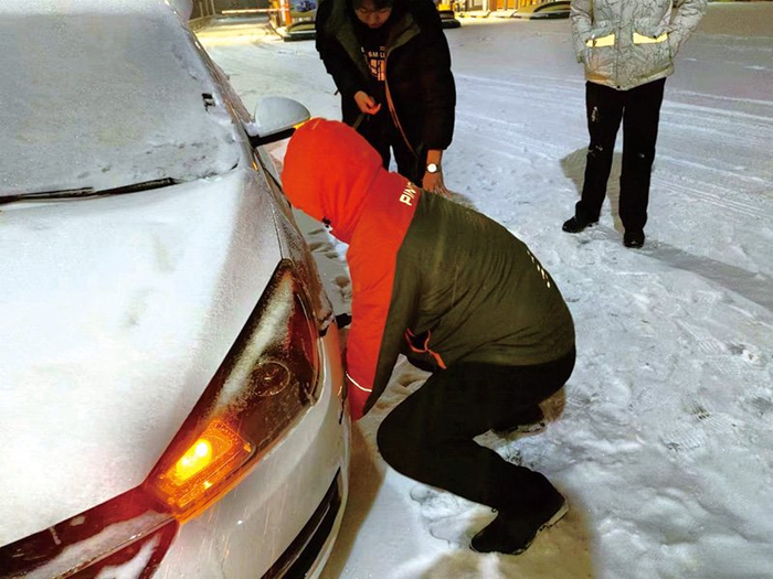 在辽宁朝阳，保险理赔员化身“修车小哥”，帮助更换事故车辆轮胎。那莹/摄