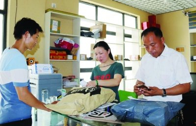 严余山（右）手机扫码替村民发货