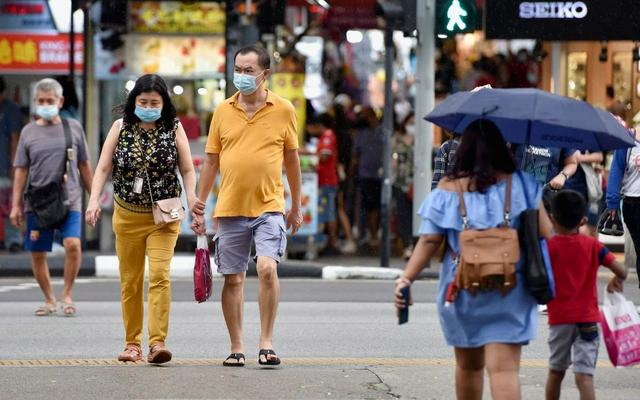 资料图：新加坡民众戴着口罩在街头行走。图/IC