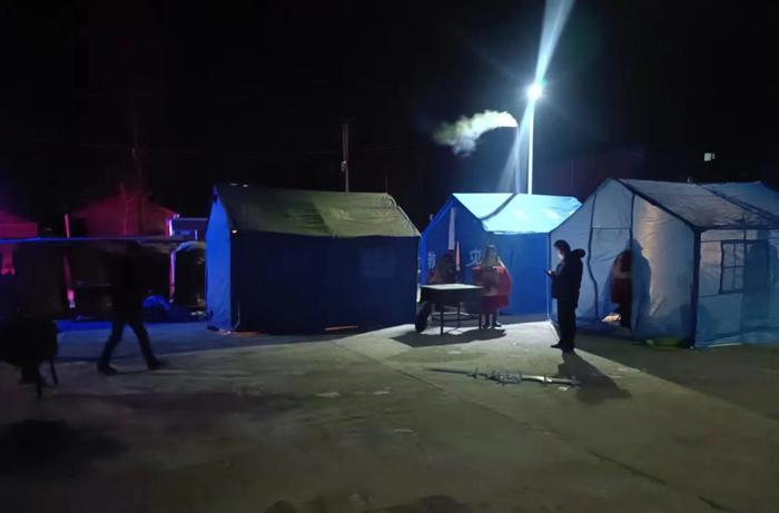 ▲震后20小时，村民得到妥善安置，安置点帐篷升起袅袅炊烟