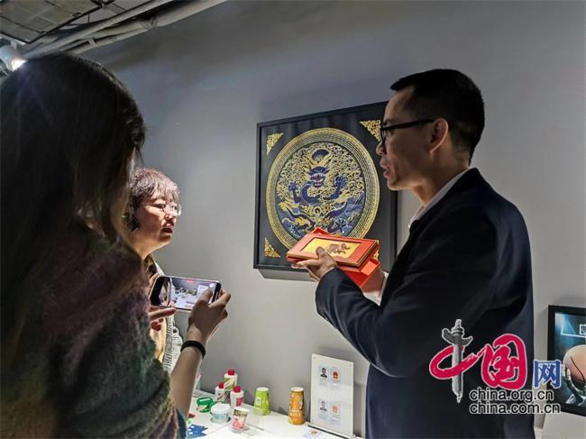 龙港印刷协会执行秘书长梁孝克介绍不同种类的印刷品。中国网记者 彭瑶 摄